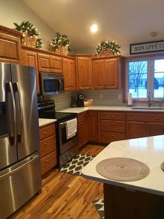 a kitchen with stainless steel appliances and wooden cabinets is pictured in this image from the front view