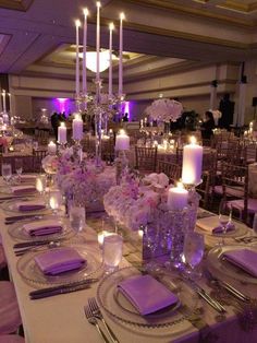 a table set with place settings, candles and napkins for an elegant wedding reception