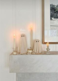 two ghost candles sitting on top of a mantle