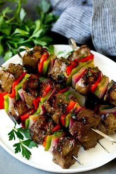 skewered meat and vegetables on a white plate