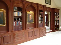 a room with bookshelves and pictures on the wall