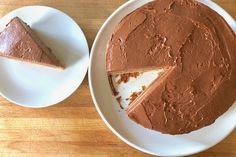 a chocolate cake on a white plate with one slice cut out and another half eaten