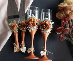 three wine glasses decorated with flowers and hearts are sitting next to each other on a table