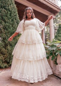 a woman in a white dress is standing outside