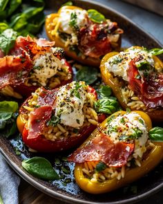 stuffed bell peppers with mozzarella cheese and spinach leaves on a platter