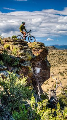 a man riding a bike on top of a cliff