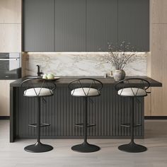 three stools sit in front of a kitchen counter