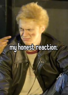 a man with blonde hair wearing a black leather jacket and white t - shirt is talking to someone