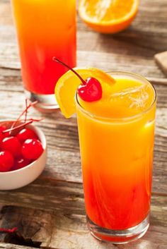 two glasses filled with orange juice and cherries