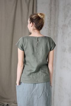 * 100% soft linen * Short sleeve * 2 buttons at the back * Handmade in Slovakia * The model is 176 cm tall, wearing size S, color Olive (this color is no longer available) Measurements: Size XS - cloth (laid on the floor): Bust: 42 cm Length (from the neckline to the hem measured from the back): 56 cm -------------------------- Size S - cloth (laid on the floor): Bust: 44 cm Length (from the neckline to the hem measured from the back): 58 cm --------------------------- Size M - cloth (laid on th Linen Blouse With Buttons, Flax Colored Tops With Buttons And Relaxed Fit, Relaxed Fit Flax Top With Buttons, Relaxed Fit Flax Colored Top With Buttons, Everyday Linen Blouse With Buttons, Green Linen Crew Neck Top, Relaxed Fit Linen Tops With Buttons, Casual Flax Top With Buttons, Casual Buttoned Beige Tops