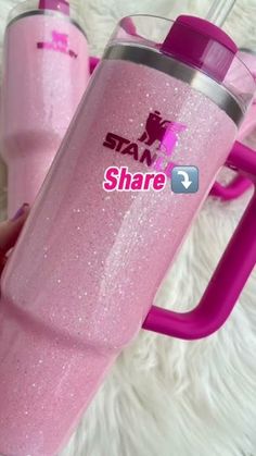 someone is holding a pink tumbler with the word share on it