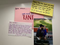 two people standing next to each other with post it notes on the wall