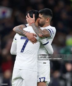 two soccer players hugging each other on the field