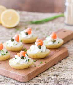 small appetizers with carrots and cream on a wooden cutting board next to a bottle of lemonade