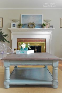 a living room with a fire place and a coffee table in front of the fireplace