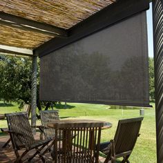 a covered patio with table and chairs under an awning