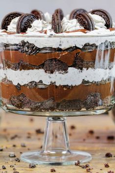 an oreo cookie dessert in a glass dish on a wooden table with chocolate chips