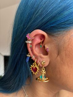 a woman with blue hair wearing ear piercings