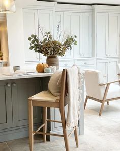 a kitchen filled with lots of white cabinets and counter top space next to a dining room table