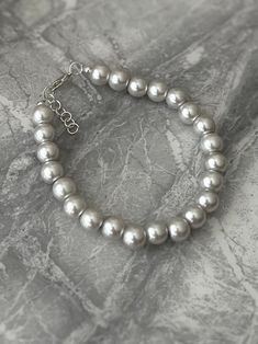 Pearl grey and silver beaded bracelet. Free glass charm with every order.  Add a touch of elegance to your wardrobe with this timeless bracelet. Handmade with love to elevate any look. Faux grey pastel pearl and silver design, which is approx 18cm in length. I have added an extendable chain so this is adjustable to fit most. The pretty pearls are attached by silver wire for extra strength.  Free shipping to UK buyers. I dispatch within 1-3 days but aim for next day postage with Royal Mail.  Presented on a gift card and wrapped beautifully in luxury tissue paper and a lovely organza bag to make the perfect gift.  Customer satisfaction is my main priority so if you are not completely in LOVE with your purchase, please let me know and you'll receive a stress free refund. These are perfect for Silver Beaded Bracelets With Pearl Charm As Gift, Minimalist Silver Beaded Bracelet With Pearl Charm, Minimalist Silver Beaded Bracelets With Pearl Charm, Silver Pearl Beaded Bracelets Minimalist Style, Silver Pearl Bracelets With 8mm Beads, Minimalist Silver Pearl Beaded Bracelets, Silver Beaded Pearl Bracelet Gift, Handmade Pearl Bracelet With Silver Accents, Silver Beaded Minimalist Pearl Bracelet