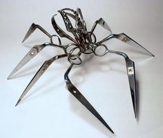 a bunch of scissors that are on some kind of stand up like a spider with sharp claws