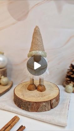 a gnome figurine sitting on top of a piece of wood next to cinnamon sticks