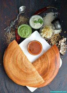 some food is on a white plate with sauces and condiments around it