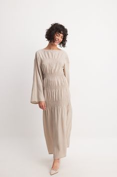 This maxi dress features a relaxed fit and a non-stretchy material. It has a stretchy smocking and a boat neck. Our maxi dress has wide long sleeves. Long Sleeve Cotton Dress, Low Waist Jeans, Boat Neck Dress, Dress Beige, Summer Wedding Dress, Sleepwear Sets, Sleeve Maxi Dress, Wedding Guest Dress Summer, Long Sleeve Maxi