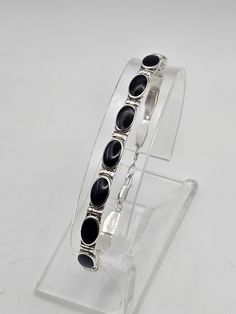 Vintage 925 Silver Modernist Black Onyx Panel Bracelet Item w#3317 This stylish vintage 925 silver black onyx panel bracelet features sleek inlaid onyx in a modernist design. With its clean lines and polished finish, this bracelet is a versatile piece that can elevate any outfit. The lobster claw clasp ensures a secure fit, making it perfect for daily wear or special occasions. Material: 925 Silver Weight: 10.7 grams Width: 5.8mm Length: 7 inches Clasp: Lobster claw Condition: Clean and in good Vintage Native American Jewelry, Vintage Designer Jewelry, Black Onyx Bracelet, Modernist Jewelry, Modernist Design, Onyx Bracelet, Bracelet Vintage, Vintage Bracelets, Native American Jewelry