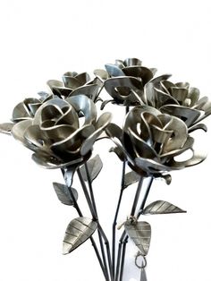 three silver roses in a vase on a white background