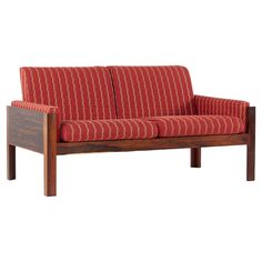 a red and white striped couch sitting on top of a wooden frame