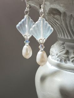 I created these 1920s inspired earrings with my favorite jewelry components - Czech glass beads, Swarovski crystals, and Swarovski pearls. This is a classic Art Deco design; perfect for a 1920s style wedding or party. The Czech beads are shaped like fans; one of the most popular design motifs during the Roaring Twenties. Elegant Swarovski crystals and pearls complete the design. One side of the clear matte Czech beads has an Aurora Borealis coating which gives a subtle shimmer of blue. These ear Handmade Art Deco Jewelry For Anniversary, Art Deco Dangle Jewelry For Vintage Events, Art Deco Earrings For Vintage Events, Vintage French Hook Earrings For Wedding, Vintage Wedding Earrings With French Hook, Vintage Jewelry With Ear Wire For Anniversary, Handmade Victorian Earrings For Vintage Events, White Art Deco Earrings For Anniversary, Art Deco Dangle Bridal Earrings For Anniversary