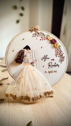 a wedding cake topper with a bride and groom on it's side, in front of a floral frame