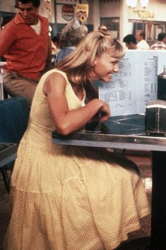 a woman sitting at a table in front of a menu