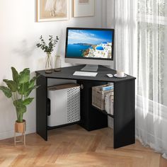 a computer desk with a monitor and keyboard on it in front of a window next to a potted plant