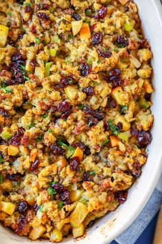 a white bowl filled with stuffing and cranberries