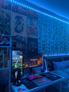 a computer desk with a keyboard, mouse and headphones on it in front of a blue wall