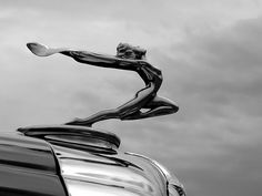 the hood ornament of a car with a statue on it's side