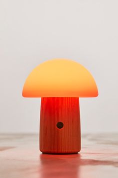 a mushroom shaped light sitting on top of a wooden table next to a white wall