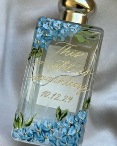 a glass bottle with blue flowers on it