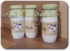 three baby bottles with cow designs on them