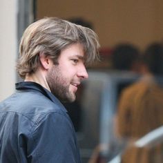 a man with long hair walking down the street