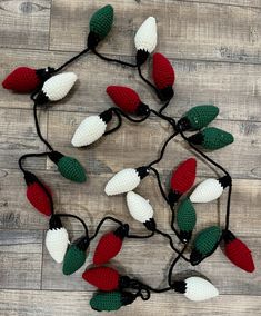 crocheted christmas lights are arranged on a wooden floor with stringing around them