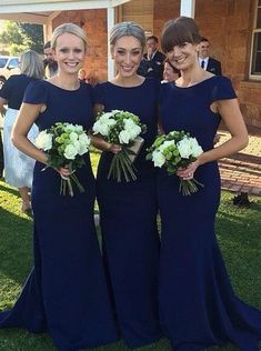 three women in blue dresses standing next to each other with bouquets on their laps