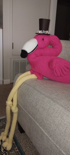 a pink flamingo sitting on top of a couch