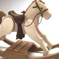 a wooden toy rocking horse with saddle and bridle on it's back