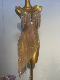 a mannequin with gold sequins and fringe on it's back