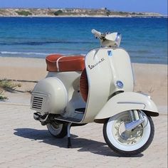 a scooter is parked on the beach near the water