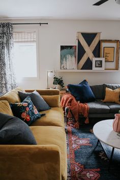 a living room filled with lots of furniture next to a wall mounted art piece on the wall