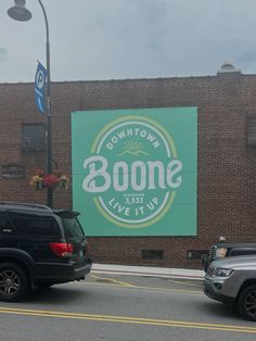 two cars parked in front of a building with a sign that says downtown boome